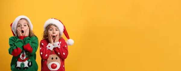 Niños Suéteres Navidad Sombreros Santa Sobre Fondo Amarillo Espacio Para — Foto de Stock