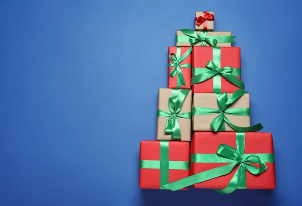 青い背景にギフトボックスのクリスマスツリー形状 フラットレイアウト テキストのスペース — ストック写真