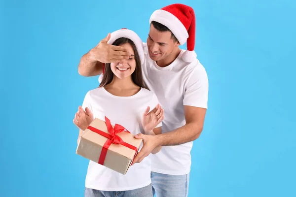 Man Presenting Christmas Gift His Girlfriend Light Blue Background Royalty Free Stock Images