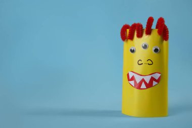 Açık mavi arka planda komik sarı canavar, mesaj için yer var. Cadılar Bayramı dekorasyonu