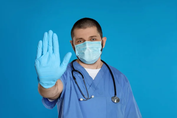 Doctor Máscara Protectora Mostrando Gesto Stop Sobre Fondo Azul Claro — Foto de Stock