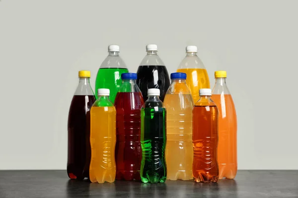 Flaschen Softdrinks Auf Dem Tisch Vor Grauem Hintergrund — Stockfoto