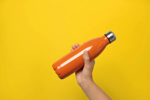 Mujer Sosteniendo Termos Naranjas Modernas Sobre Fondo Amarillo Primer Plano — Foto de Stock