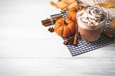 Lezzetli balkabaklı latte ve beyaz ahşap masadaki malzemeler. Metin için boşluk