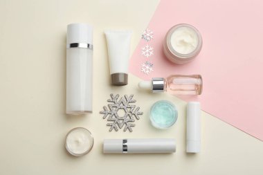 Pembe ve bej arka planda kozmetik ürünleri olan düz kompozisyon. Kış bakımı