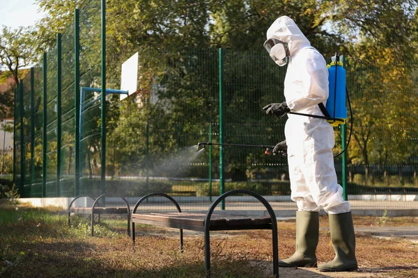 Persona Traje Materiales Peligrosos Rociando Desinfectante Banco Aire Libre Tratamiento — Foto de Stock