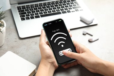 Wi-Fi 'a bağlanan kadın masadaki cep telefonunu kullanıyor, yakın plan