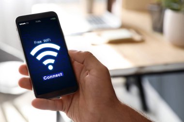Wi-Fi 'a bağlanan adam cep telefonunu içeride kullanıyor, yakın plan.