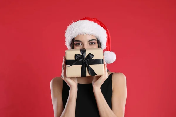 Siyah Elbiseli Kadın Noel Baba Şapkalı Kırmızı Arka Planda Noel — Stok fotoğraf