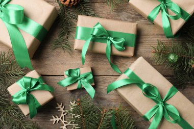 Tahta masa üzerinde hediye kutuları ve Noel süslemeleri olan düz bir kompozisyon.