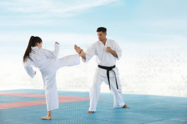 Tatami 'de koçla karate yapan bir kız.