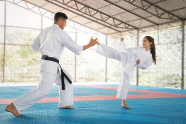 Tatami 'de koçla karate yapan bir kız.