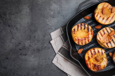 Gri masadaki bademli enfes ızgara şeftaliler, üst manzara. Metin için boşluk