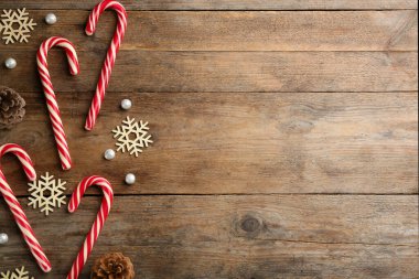Düz kompozisyon, baston şekerler ve ahşap arka planda Noel dekoru. Metin için boşluk