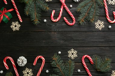 Siyah ahşap masanın üzerinde şeker kamışı ve Noel dekoru olan düz bir kompozisyon vardı. Metin için boşluk