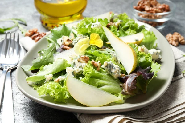 Gri masada armutlu taze salata.