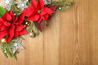 Noktalı düz kompozisyon (geleneksel Noel çiçekleri) ve ahşap masa üzerinde bayram dekoru. Metin için boşluk