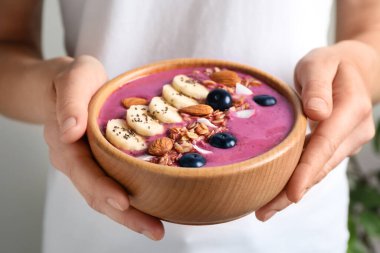 Tatlı kasesi elinde nefis acai smoothie, yakın çekim manzaralı bir kadın.