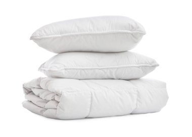 Beyaz arka planda yastıkları olan yumuşak bir battaniye.