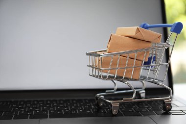 İnternet alışverişi. Modern dizüstü bilgisayarda kutuları olan küçük bir araba, metin için boşluk