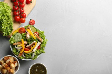 Lezzetli tavuk salatası ve gri masada taze sebzeler. Metin için boşluk