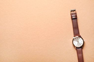 Bej arka planda lüks bir kol saati, üst manzara. Metin için boşluk