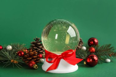 Güzel bir Noel kar küresi ve yeşil arka planda şenlikli bir dekor