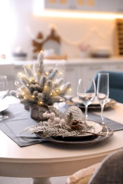 Bulaşık takımlı bir masa ve mutfakta güzel bir Noel süsü. İç tasarım