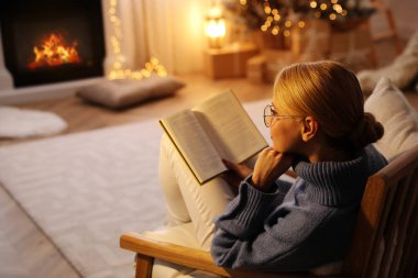Evde kitap okuyan genç bir kadın, mesaj yazacak yer. Noel kutlaması