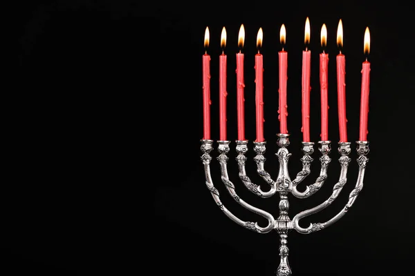 Silver menorah with burning candles on black background, space for text. Hanukkah celebration