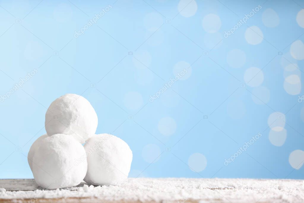 Snowballs on table against blurred lights, space for text