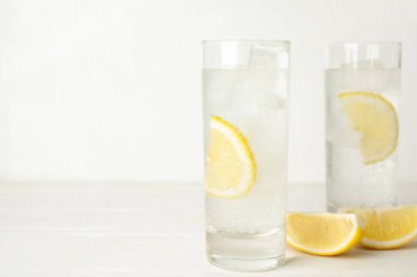 Limon dilimli soda ve beyaz ahşap masada buz küpleri. Metin için boşluk