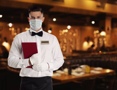 Restoranda tıbbi maske takan garson. Metin için boşluk