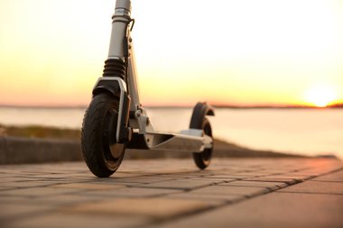 Günbatımında modern elektrikli scooter, yakın plan.