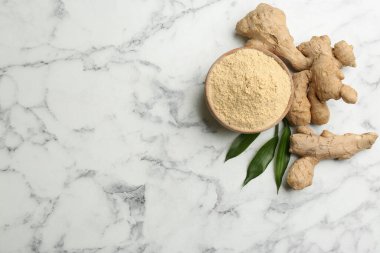 Kuru zencefil tozu, taze kök ve yapraklar beyaz mermer masada, düz yerde. Metin için boşluk