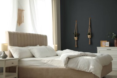 Şık oda içinde yumuşak battaniyeli rahat bir yatak.