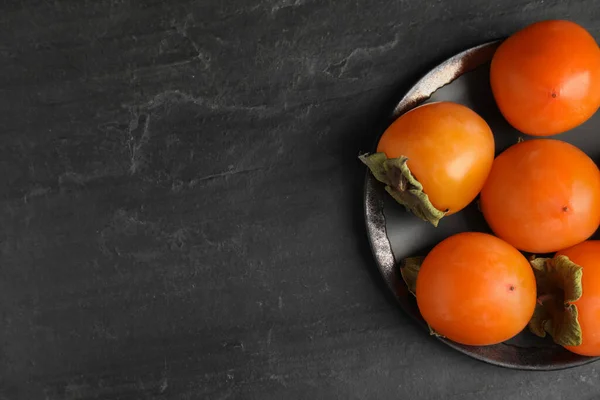黒スレートテーブルの上でおいしい熟した柿 トップビュー テキストのスペース — ストック写真