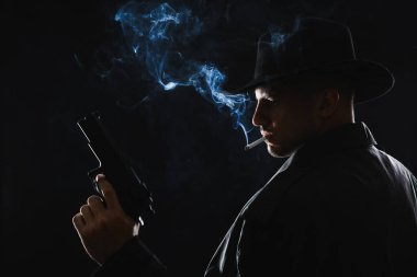 Siyah arka planda sigara içen eski moda dedektif.