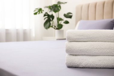 İçerideki yatakta temiz havlu yığını, yakın plan. Metin için boşluk