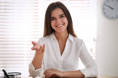 Ofisteki video konferansında iş arkadaşlarıyla konuşan genç bir kadın, webcam 'den görüntüsü
