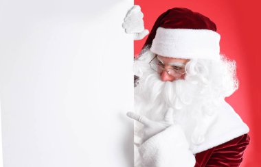 Kırmızı arka planda boş pankart tutan Noel Baba