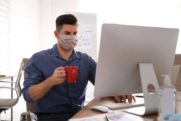 Worker with mask in office. Protective measure during COVID-19 pandemic