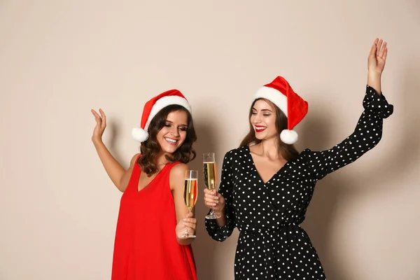 Jolies Femmes Chapeaux Père Noël Avec Champagne Sur Fond Beige — Photo