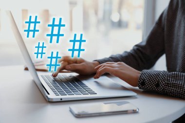 Sofrada modern laptop kullanan bir kadın, yakın plan. Aygıt üzerine etiket simgeleri