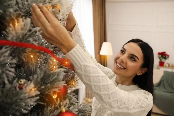 Ung Kvinde Dekorere Juletræ Derhjemme - Stock-foto