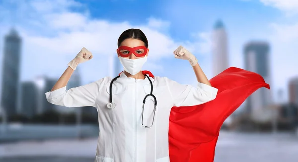 Doctor dressed as superhero on city background. Medical workers fighting with dangerous diseases