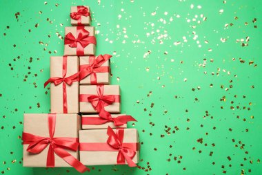 Yeşil arka planda farklı hediye kutularıyla yapılmış Noel ağacı. Metin için boşluk