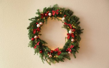 Aydınlık duvarında şenlik dekoru olan güzel Noel çelengi