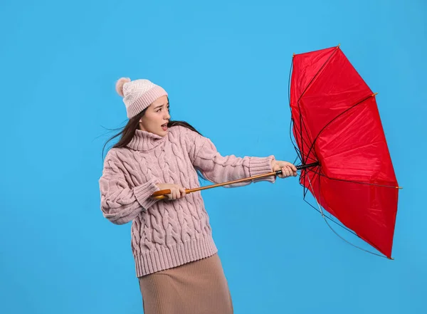 Ung Kvinna Med Paraply Fångas Vindpust Ljusblå Bakgrund — Stockfoto