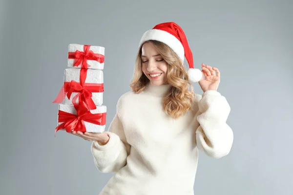 Όμορφη Νεαρή Γυναίκα Σάντα Καπέλο Χριστουγεννιάτικα Δώρα Ανοιχτό Γκρι Φόντο — Φωτογραφία Αρχείου